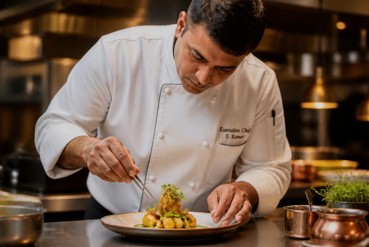 Chef plating a gourmet dish at Swad Restaurant